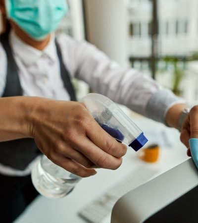 Close-up of businesswoman cleaning her computer while working in the office.
