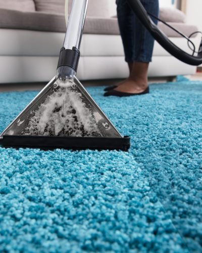 Person Using Vacuum Cleaner For Cleaning Carpet