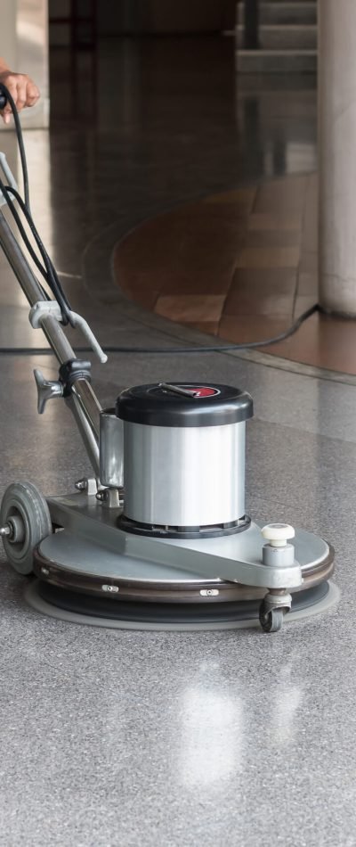 Woman worker cleaning the floor with polishing machine